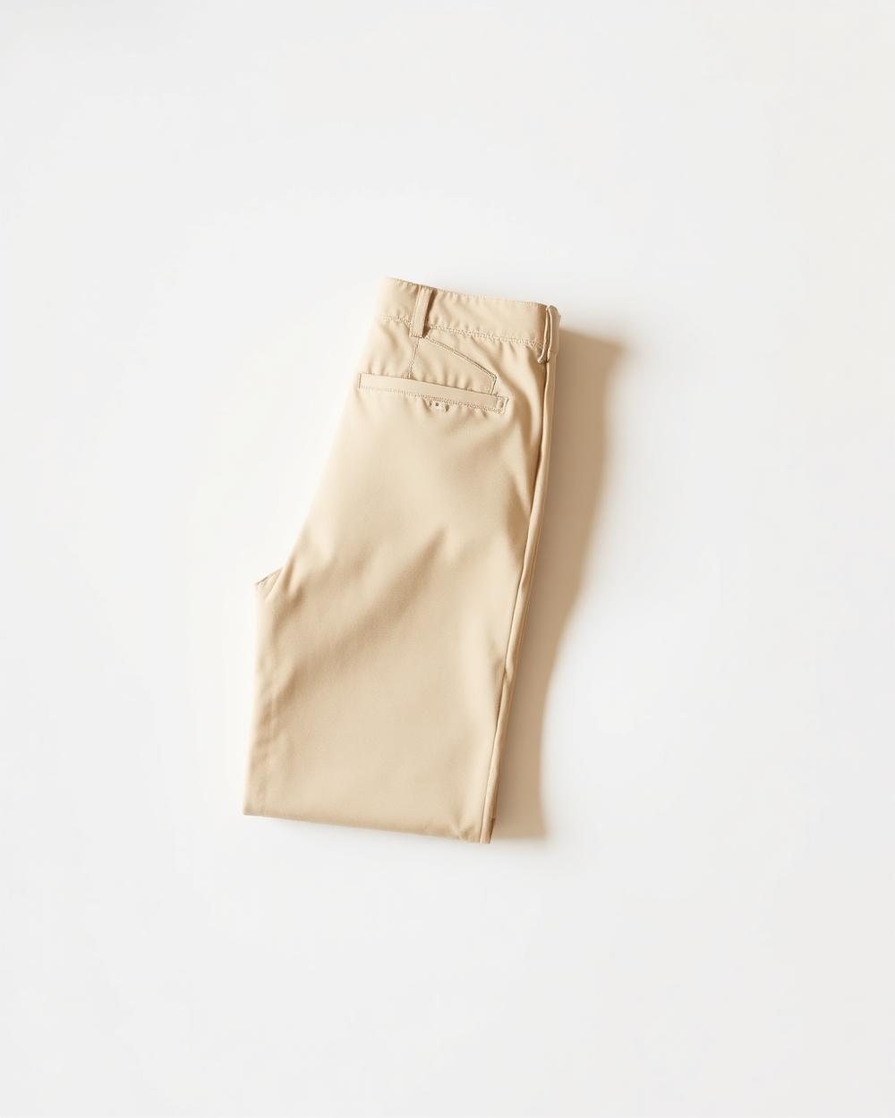 Pantalon droit couleur sable plié sur fond blanc cassé